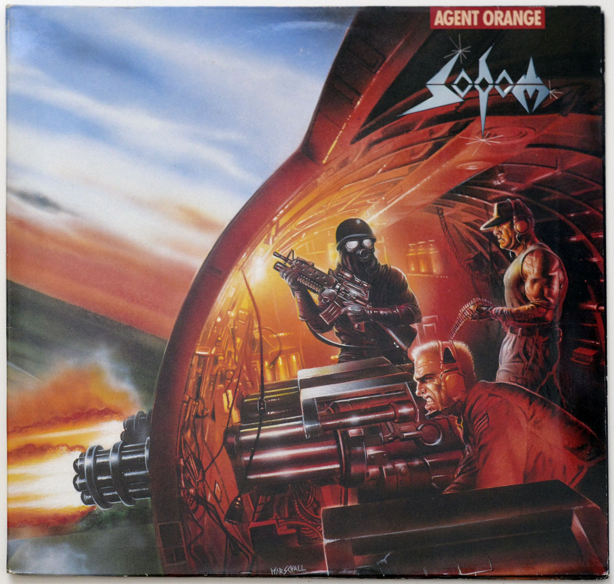 Album cover of Agent Orange by Sodom, featuring a dramatic scene inside a military aircraft with soldiers operating heavy artillery. The artwork, dominated by fiery orange and red hues, depicts a grim, war-torn atmosphere with detailed weaponry, tactical uniforms, and glowing explosions outside.